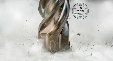 Nahaufnahme eines rotierenden Metallbohrers der Marke PROJAHN beim Bohren in Beton, mit Funken und Staub – Präzisionswerkzeuge für Handwerk und Industrie in Plettenberg.